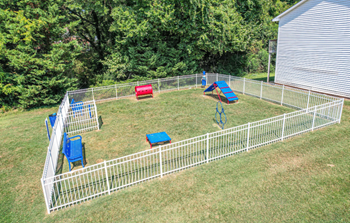 a fenced in backyard with a play area for dogs at Ashbrook Village, Gastonia, 28054